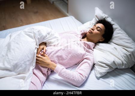 Afroamerikanische Frau Mit Magenschmerzen Beim Schlafen Stockfoto