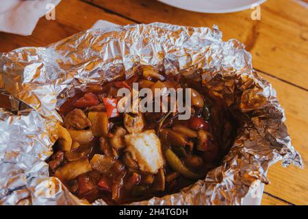Blick von oben auf ein traditionelles bosnisches Gericht namens „hadzijski cevap“, das in einer Folie in einem Restaurant serviert wird Stockfoto