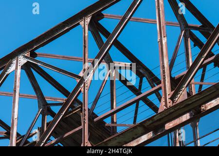 Nahaufnahme eines alten verrosteten industriellen Schwerlastkrans gegen den blauen Himmel Stockfoto