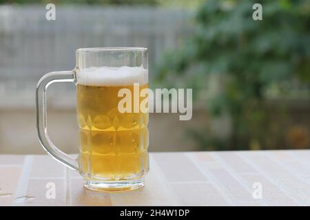 Kaltes Bier im Glas mit verschwommenem Hintergrund Stockfoto