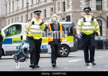 London, England, Großbritannien. November 2021. Die britische Polizei nimmt Verhaftungen vor, während Klimaaktivisten eine Demonstration inszenieren und die Straßen um den Parliament Square blockieren. Während der Demonstration klebten sich Mitglieder der Beleidigung Großbritanniens an die Straßen rund um den Parliament Square. Quelle: Rasid aSlim/ZUMA Wire/Alamy Live News Stockfoto