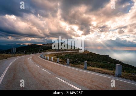 Bergstraße bei Sonnenuntergang. Leere Asphaltstraße durch die Berge des Naturparks Serra Da Estrela im Norden Portugals Stockfoto