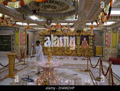 Mumbai, Indien. November 2021. Ein Mann reinigt den Boden im Swaminarayan-Tempel in Dadar in Mumbai.Chopda (Bücher von Konten) Poojan-Rituale wurden in den Tempelräumen durchgeführt und eifrige Anhänger beobachteten das gleiche online, wie es Einschränkungen bei der Sammlung von Menschen aufgrund einer Coronavirus-Pandemie gab. Kredit: SOPA Images Limited/Alamy Live Nachrichten Stockfoto