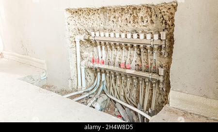 Anordnung von Rohren und Sensoren für die Fußbodenheizung in der Wand eines unfertigen Hauses Stockfoto