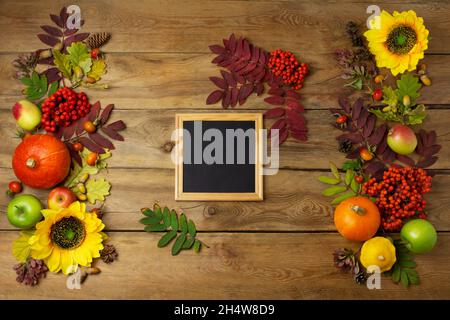 Hölzerner quadratischer Bilderrahmen mit Sonnenblumen, Kürbissen und Herbstblättern. Leerer Rahmen rustikales Modell für Präsentationsdesign. Schablonenrahmen für Stockfoto