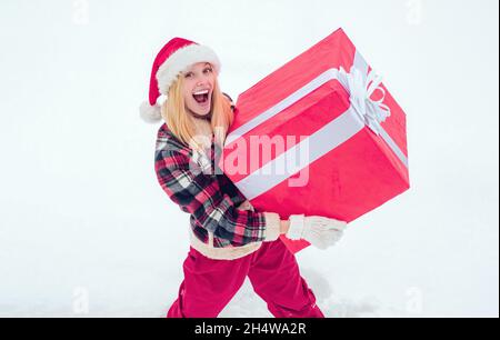 Winter Frau mit Geschenk. Porträt der Weihnachtsfrau mit riesigen roten Geschenk Blick auf die Kamera. Weihnachtsfrau mit einem riesigen Geschenkkarton. Lotteriegewinnerin Stockfoto