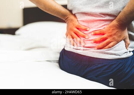 Mann mit Rückenschmerzen im Schlafzimmer. Stockfoto