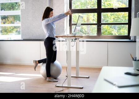 Übung Zum Dehnen Der Mitarbeiter Am Schreibtisch Im Büro Stockfoto