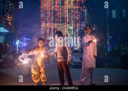 Ghaziabad, Indien. November 2021. Indische Jungen spielen während der Diwali-Feier in Ghaziabad mit Wunderkerzen.Indische Staaten und Gewerkschaftsgebiete haben Richtlinien erlassen, die die Verwendung von Feuerwerkskörpern gemäß den Befehlen des Obersten Gerichtshofs einschränken, aber die Menschen feierten immer noch mit einem Verbot von Feuerwerkskörpern. Kredit: SOPA Images Limited/Alamy Live Nachrichten Stockfoto