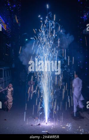 Ghaziabad, Indien. November 2021. Indische Jungen spielen während der Diwali-Feier in Ghaziabad mit einem Brunnenfeuerwerk.Indische Staaten und Gewerkschaftsgebiete haben Richtlinien erlassen, die die Verwendung von Feuerwerkskörpern gemäß den Befehlen des Obersten Gerichtshofs einschränken, aber die Menschen feierten immer noch mit einem Feuerwerkskörper-Verbot. Kredit: SOPA Images Limited/Alamy Live Nachrichten Stockfoto