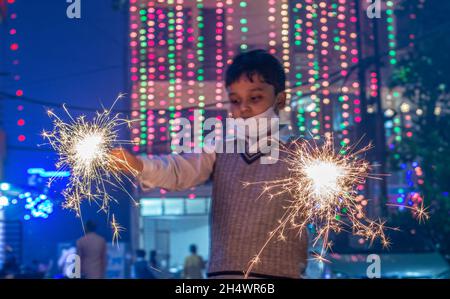 Ghaziabad, Indien. November 2021. Indian Boy spielt während der Diwali-Festfeier in Ghaziabad mit Wunderkerzen.Indische Staaten und Gewerkschaftsgebiete haben Richtlinien erlassen, die die Verwendung von Feuerwerkskörpern gemäß den Befehlen des Obersten Gerichtshofs einschränken, aber die Menschen feierten immer noch mit einem Feuerwerkskörper-Verbot. Kredit: SOPA Images Limited/Alamy Live Nachrichten Stockfoto