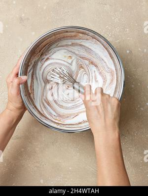 Schokoladenkuchen Teig Herstellung Prozess, Mischen Joghurt in den Teig, Draufsicht Stockfoto