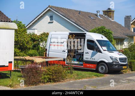 Weißer Mercedes-Benz Sprinter-Transporter von Reparaturbauunternehmen parkte während der Renovierung vor einem Haus Stockfoto