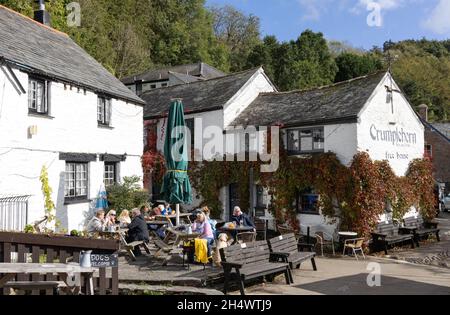 Englischer Dorfpub - Menschen, die an einem sonnigen Tag im Oktober vor dem Crumpelhorn Inn oder Free House, dem Dorf Polperro, Polperro, Großbritannien, sitzen Stockfoto