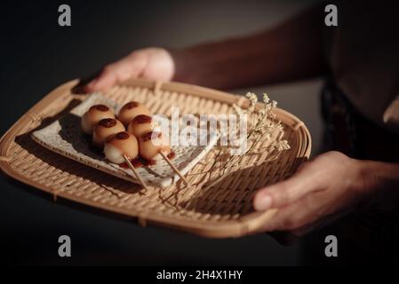 Gerösteter Mitarashi Dango im Holztablett, einem der beliebtesten japanischen Straßengerichte. Stockfoto