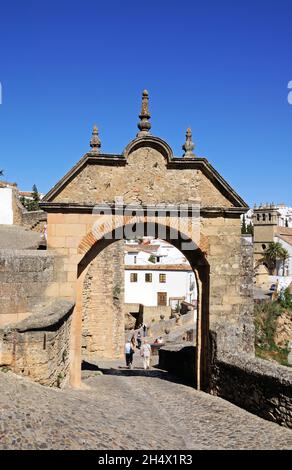 Blick durch den Philip V Bogen in Richtung Altstadt und Nuestro Padre Jesus Kirche, Ronda, Provinz Malaga, Spanien. Stockfoto