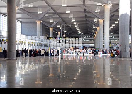 Passagiere, die auf den Check-in für Flüge in der Abflughalle von Terminal 3 am Flughafen Malaga, Malaga, Costa del Sol, Spanien warten Stockfoto