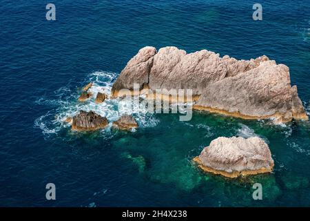 Große Felsen im blauen ionischen Meer klares, tiefes, lebendiges Wasser. Sommer Natur auf der Insel Lefkada, Griechenland. Ansicht von oben Stockfoto