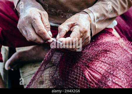 HURGHADA, ÄGYPTEN - 31. OKTOBER 2021 - Ein Fischer flickt ein Fischernetz, Hurghada, Ägypten. Stockfoto