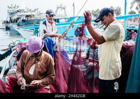 HURGHADA, ÄGYPTEN - 31. OKTOBER 2021 - Fischer reparieren ein Fischernetz, Hurghada, Ägypten. Stockfoto