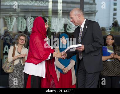 Brian Gambles (Direktor, Library of Birmingham) übergab Malala Yousafzai bei der Eröffnung der neuen Library of Birmingham, Centenery Square am 3. September 2013 - Birmingham, ein Exemplar des Buches „Philosophy Shop“ Stockfoto