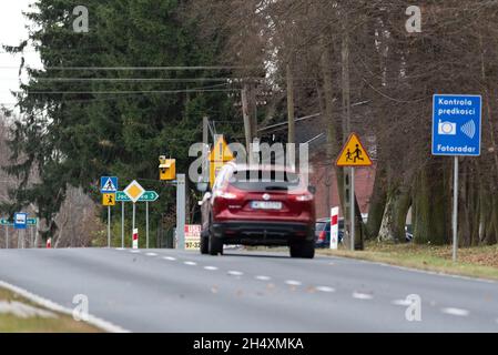 Szadki, Polen - 5. November 2021: Blitzer am Fußgängerübergang vor der Kreuzung. Informationsschilder zur Geschwindigkeitsmessung in Stockfoto