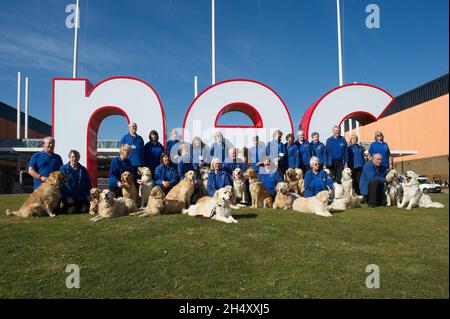 Mitglieder der South Golden Retriever Society und ihre Hunde, die vor dem NEC posieren, unterschreiben am 3. Tag der Crufts 2015 am 7. März 2015 im NEC in Birmingham, Großbritannien Stockfoto