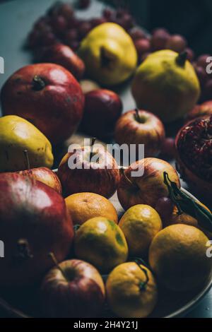 Dunkle barocke Renaissance-Still-Life-Fotografie von Früchten und Blumen. Äpfel, Trauben, Granatapfel, Quitte. Stockfoto