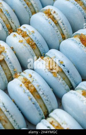 Viele blaue Makronen liegen in der Verpackung aus der Nähe. Stockfoto