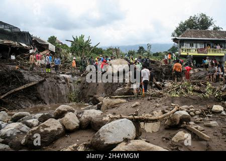 Malang, Indonesien. November 2021. Rettungskräfte und lokale Menschen versuchen, einen Felsen während einer Suchaktion zu bewegen, nachdem eine Sturzflut durch starke Regenfälle das Dorf Bulukerto in Malang, Ost-Java, Indonesien, am 5. November 2021 getroffen hat. Quelle: Kurniawan/Xinhua/Alamy Live News Stockfoto