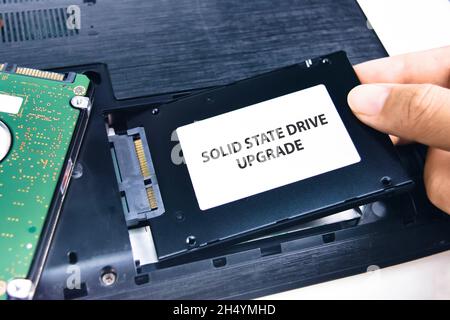 Ein Techniker installiert ein Solid-State-Laufwerk (SSD) in einem Laptop Stockfoto