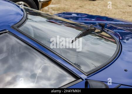 Nahaufnahme der gekrümmten Windschutzscheibe und des Scheibenwischers eines blauen Lancia Stratos HF Stradale klassischen italienischen Sport-Rallye-Autos. Stockfoto