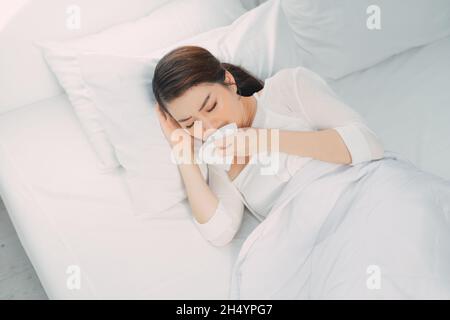 Kranke junge Frau im Bett zu Hause. Influenza-Virus Stockfoto