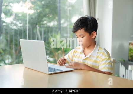 Kleiner Junge in virtueller Klasse. Schule zu Hause Stockfoto