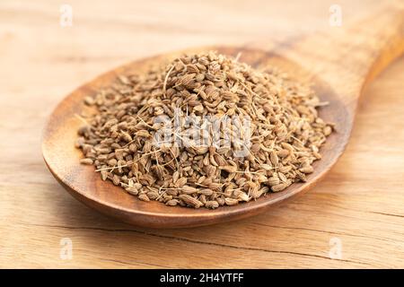 Aniswürzsamen in Holzlöffel auf Holztisch. Nahaufnahme Stockfoto