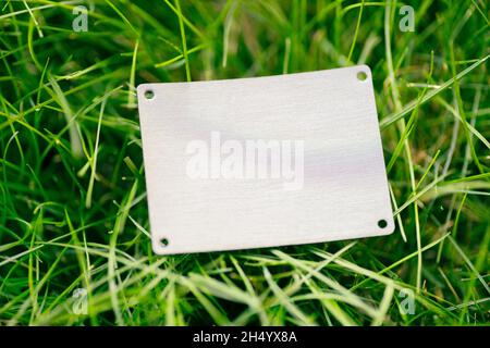 Kreative Layout Komposition Rahmen aus grünem Rasen Rasen mit quadratischem Lederpatch für Kleidung für Fabrik flach legen und Kopie Platz für Logo Stockfoto