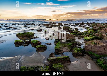 Ruhiger und einsamer Strand mit Felsen bei Sonnenuntergang in der Stadt Torres in Rio Grande do Sul Stockfoto