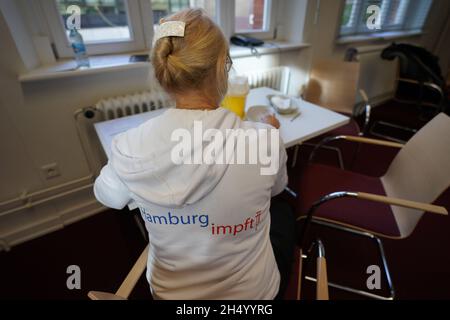 Hamburg, Deutschland. November 2021. Ein Mitglied des Mobile Impfteams bereitet eine Impfung an der Staats- und Universitätsbibliothek Hamburg vor. Ein Sprecher der Gesundheitsbehörde sagte, dass beim offenen Impfangebot genügend Corona-Impfstoff auf Lager war, um allen zu dienen. (To dpa 'offenes Impfangebot in der Universitätsbibliothek - lange Schlange vor der Tür') Quelle: Marcus Brandt/dpa/Alamy Live News Stockfoto