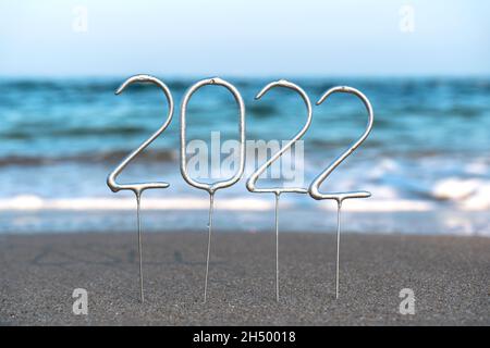 Zahlen für das kommende neue Jahr 2022 inmitten von Wellen am Strand. Das Konzept der Feierlichkeiten zum neuen Jahr in einem exotischen Land Stockfoto