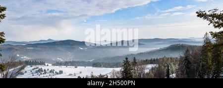 Panorama der nebligen Winterlandschaft der Beski Sadecki Bergkette bei Krynica Zdroj, Polen Stockfoto