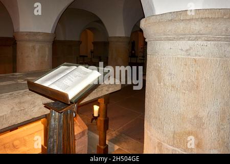 Hildesheim, 4. November 2021: Die Bibel öffnete sich auf einem Rednerpult zwischen den mächtigen Säulen der Krypta Stockfoto