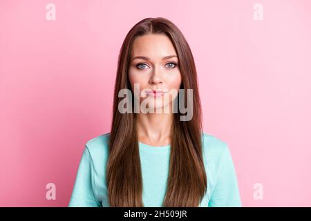 Porträt von jungen attraktiven ernst ruhig intelligente Frau tragen türkisfarbenen T-Shirt-Look Kamera isoliert auf rosa Hintergrund Stockfoto