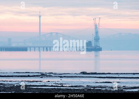 Nebliger Morgen am Firth of Forth mit Blick auf die Straßen- und Eisenbahnbrücken vom Fife Coastal Path aus gesehen. Stockfoto