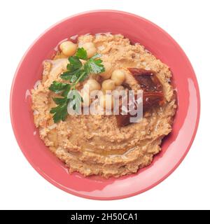 Flacher Laienblick auf den Hummus mit Bohnen, sonnengetrockneten Tomaten und grünen Korianderblättern, isoliert auf weißem Hintergrund. Beschneidungspfad hinzugefügt Stockfoto