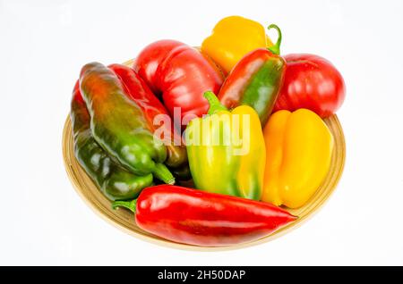 Anordnung von bunt frisch sortierten Paprika und Tomaten in Holzplatte auf weißem Hintergrund. Studio Photo Stockfoto