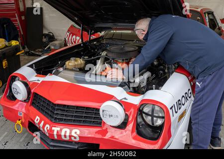 Mechaniker bei der Arbeit am 1979 Bastos Chevrolet Camaro Z28 in der Garage beim Goodwood 78. Mitgliedertreffen, Sussex, Großbritannien. Stockfoto