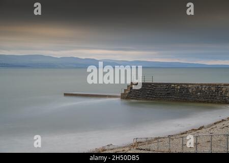 Der Pier und Wellenbrecher in Criccieth North Wales. An einem stürmischen Nachmittag. Stockfoto