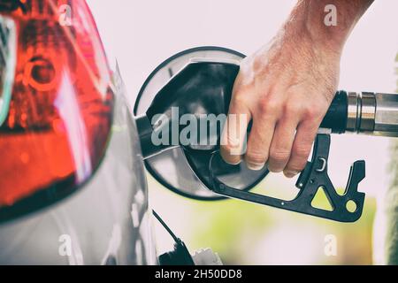 Person der Gaspumpe pumpt Kraftstoff, der den Autotank an der Tankstelle füllt. Handgriff mit Düse Auftanken. Preis für Benzin. Stockfoto