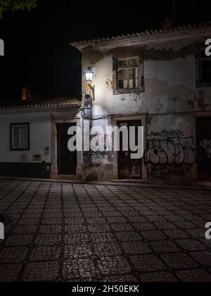 Lagos, Algarve, Portugal - 2 2021. November: Heruntergekommenes und verfallendes Gebäude mit kaputten, mit Graffiti bedeckten Fenstern auf der Rua Marreiros im historischen Zentrum Stockfoto