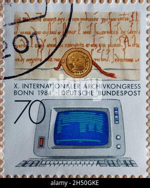 DEUTSCHLAND - UM 1984 : eine Briefmarke aus Deutschland, die ein Dokument aus dem Mittelalter und ein veraltetes Datendisplay zeigt. Internationale Archi Stockfoto